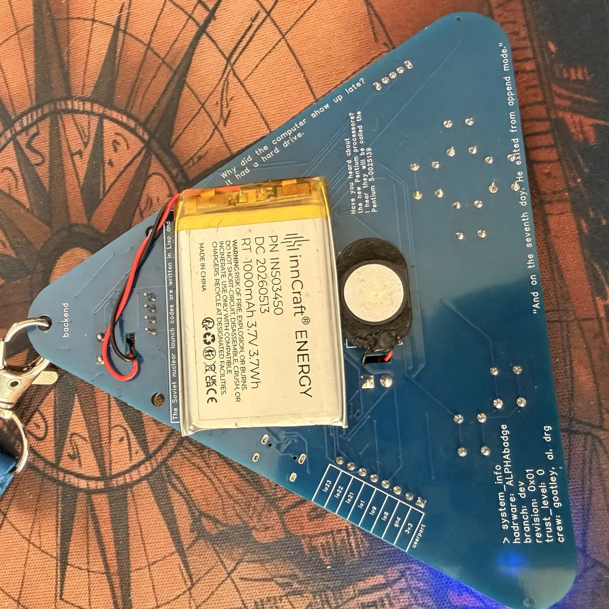 Back of the Alphacon badge - battery, buzzer and the userport header